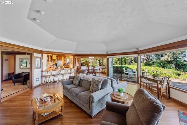 1230 Seagate Ave, Coos Bay, OR 97420 - living area featuring a textured ceiling, vaulted ceiling, wood finished floors, and baseboards