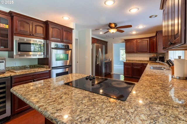 416 Elmar Dr, Winchester, OR 97495 - kitchen with appliances with stainless steel finishes, wine cooler, a sink, ceiling fan, and glass insert cabinets