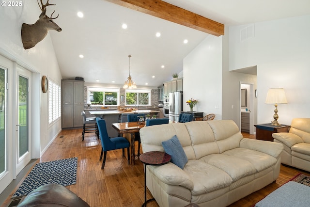 living area featuring visible vents, light wood-type flooring, high vaulted ceiling, beam ceiling, and recessed lighting