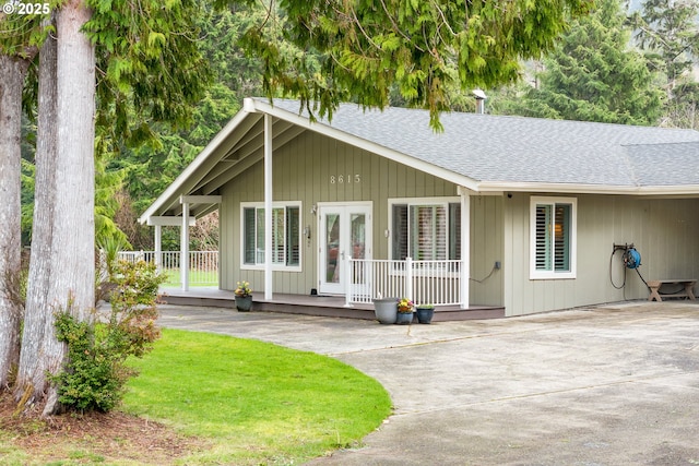 view of front of home with french doors, a porch, and roof with shingles