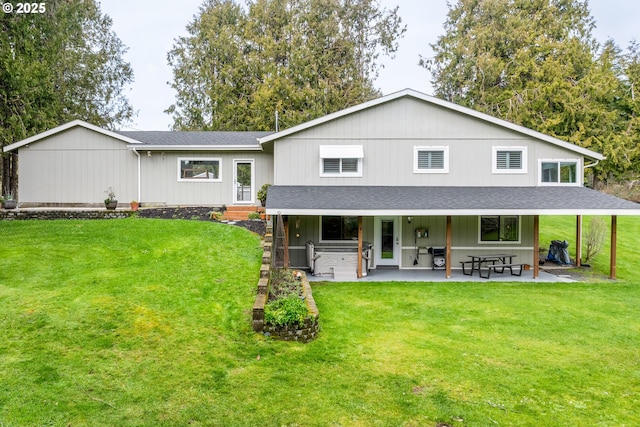 rear view of property with roof with shingles, a lawn, and a patio area