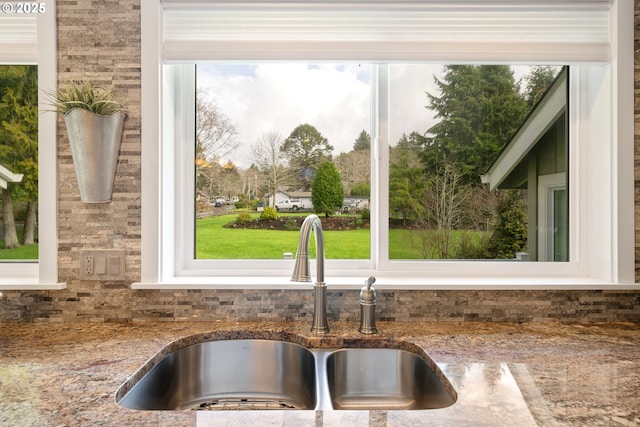 kitchen featuring stone counters and a sink