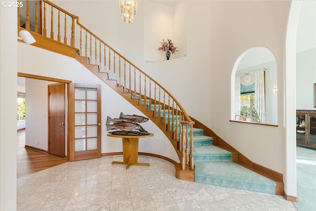 300 SE Arrow Creek Ln, Gresham, OR 97080 - staircase with a towering ceiling, baseboards, arched walkways, and a chandelier
