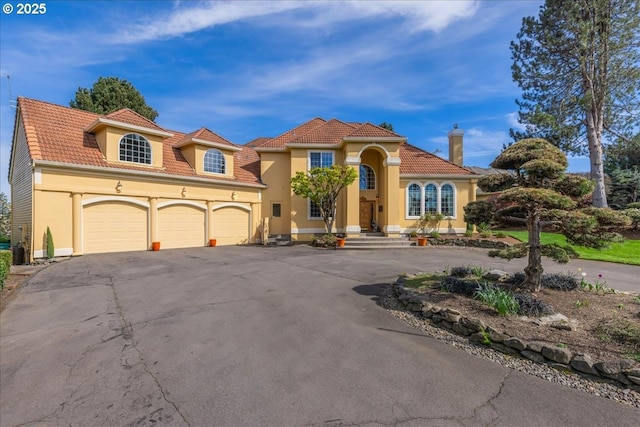 300 SE Arrow Creek Ln, Gresham, OR 97080 - mediterranean / spanish-style house featuring asphalt driveway, a tile roof, stucco siding, and a garage