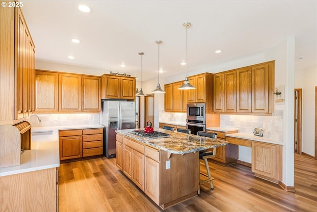 300 SE Arrow Creek Ln, Gresham, OR 97080 - kitchen with appliances with stainless steel finishes, a kitchen island, light wood-style floors, tasteful backsplash, and a sink