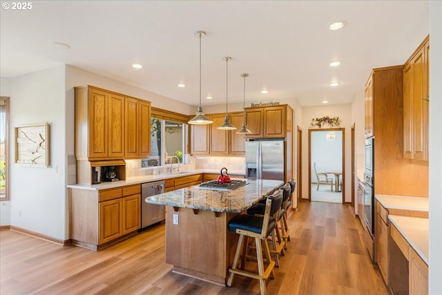 300 SE Arrow Creek Ln, Gresham, OR 97080 - kitchen featuring stainless steel appliances, a sink, a kitchen island, brown cabinetry, and recessed lighting