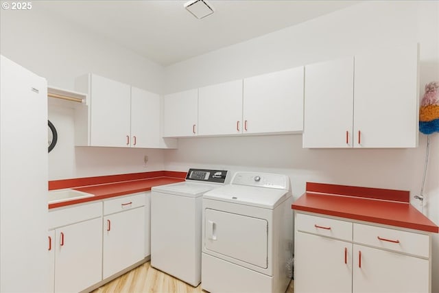 300 SE Arrow Creek Ln, Gresham, OR 97080 - laundry room with washer and dryer, cabinet space, and light wood-type flooring