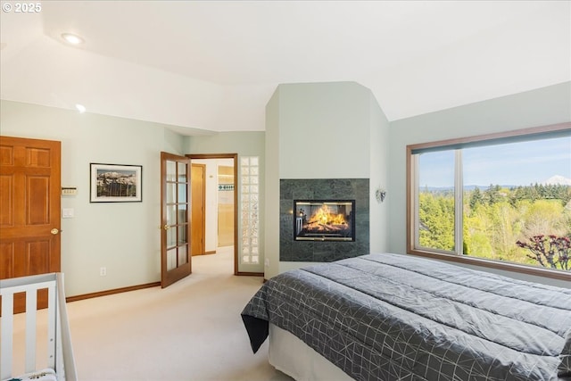 300 SE Arrow Creek Ln, Gresham, OR 97080 - bedroom with light carpet, baseboards, a glass covered fireplace, vaulted ceiling, and french doors