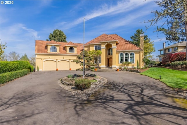 300 SE Arrow Creek Ln, Gresham, OR 97080 - mediterranean / spanish-style house featuring asphalt driveway, a tiled roof, stucco siding, and an attached garage