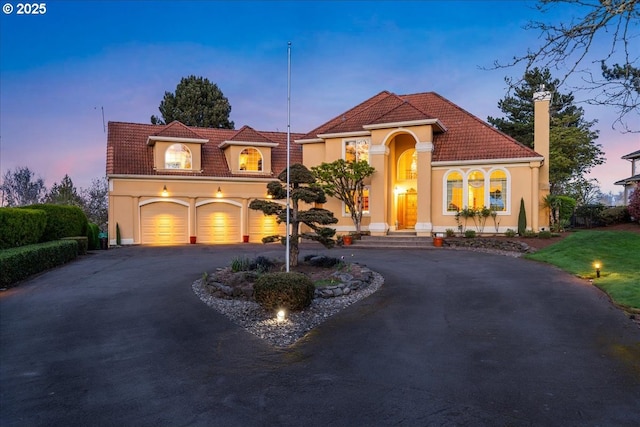 300 SE Arrow Creek Ln, Gresham, OR 97080 - mediterranean / spanish house featuring driveway, a tile roof, stucco siding, and an attached garage