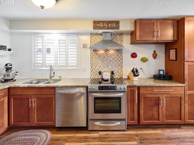 427 E Clackamas Cir, Woodburn, OR 97071 - kitchen featuring stainless steel appliances, brown cabinetry, wall chimney exhaust hood, and a sink