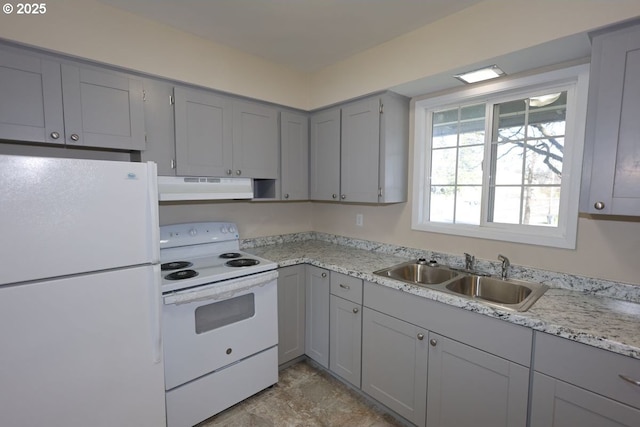 kitchen featuring white appliances, gray cabinets, a sink, and under cabinet range hood