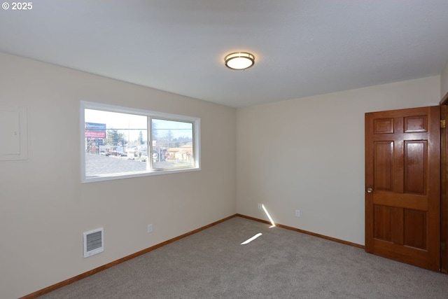 spare room featuring baseboards, visible vents, and carpet flooring