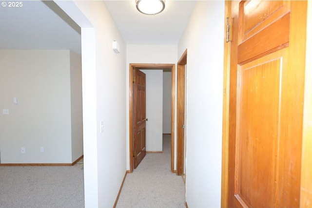 hallway with light carpet and baseboards