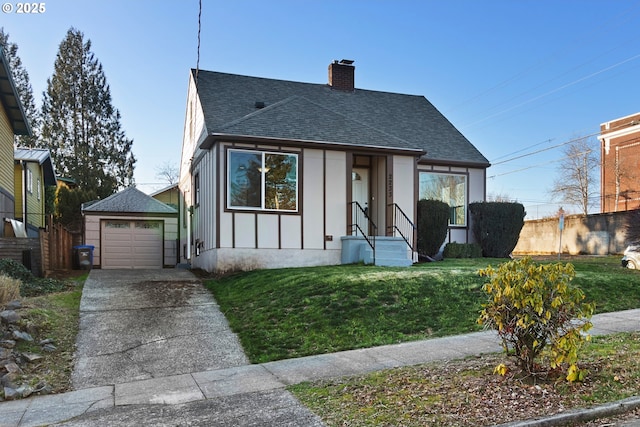 bungalow-style home featuring a garage, an outdoor structure, and a front yard