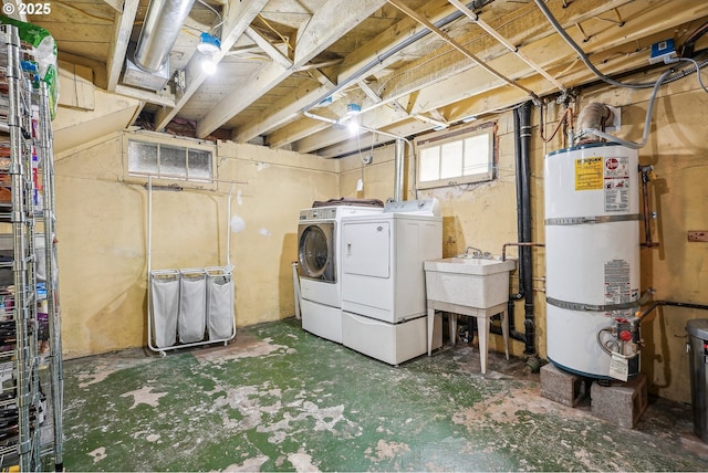 clothes washing area with laundry area, a sink, water heater, and washer and dryer