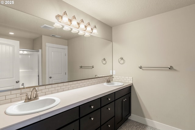 bathroom with double vanity, visible vents, baseboards, and a sink