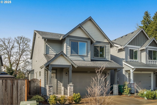 craftsman-style home featuring roof with shingles, fence, and an attached garage