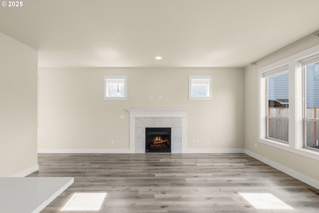 unfurnished living room featuring a fireplace, baseboards, wood finished floors, and recessed lighting