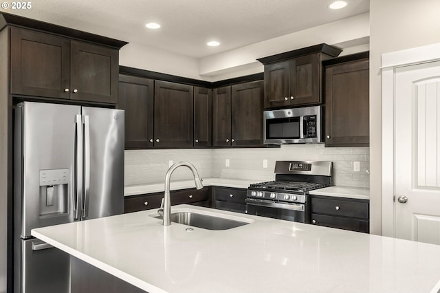 kitchen with backsplash, stainless steel appliances, a sink, and light countertops