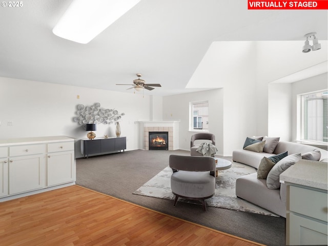 15325 NW Central Dr Unit 301, Portland, OR 97229 - living area featuring plenty of natural light, a ceiling fan, a tiled fireplace, and light wood-style floors