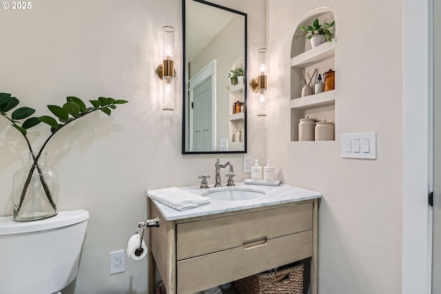 half bath featuring toilet, vanity, and built in features