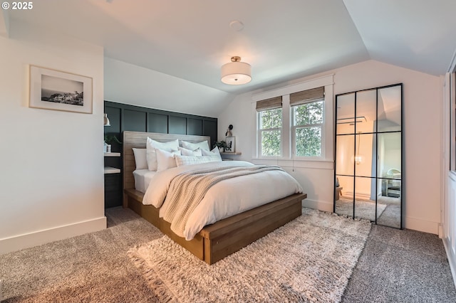 bedroom with carpet, baseboards, and vaulted ceiling