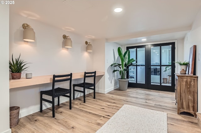 interior space with recessed lighting, baseboards, wood finished floors, and french doors