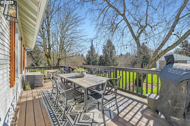 wooden terrace featuring outdoor dining area and grilling area