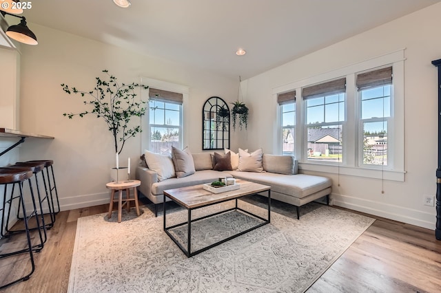 living area featuring recessed lighting, baseboards, and wood finished floors