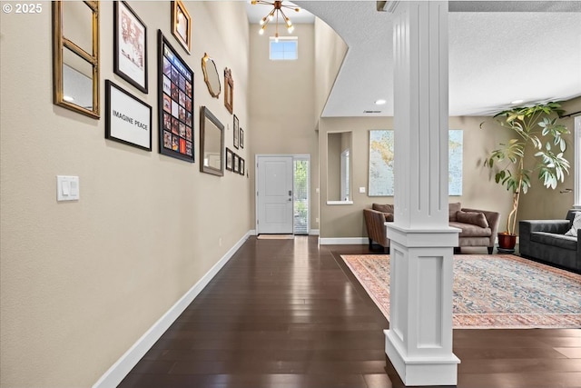 21615 SW Derby Ter, Sherwood, OR 97140 - foyer with decorative columns, dark wood-type flooring, baseboards, arched walkways, and a textured ceiling