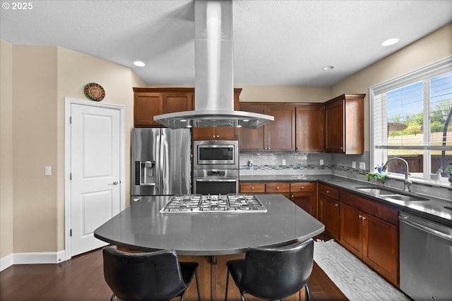 21615 SW Derby Ter, Sherwood, OR 97140 - kitchen featuring appliances with stainless steel finishes, a sink, island exhaust hood, baseboards, and dark countertops