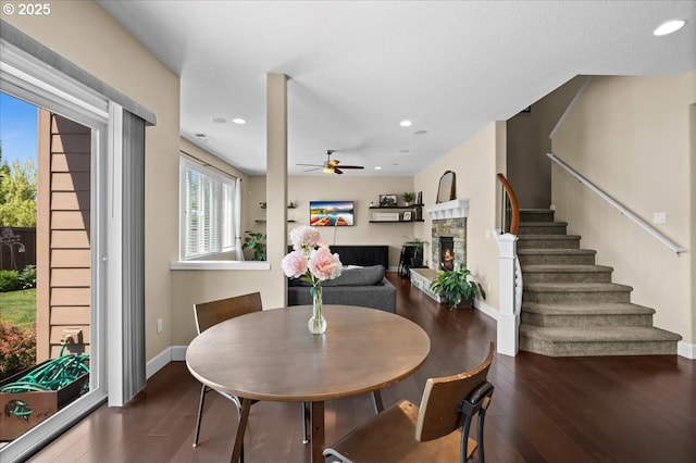 21615 SW Derby Ter, Sherwood, OR 97140 - dining area with wood finished floors, ceiling fan, baseboards, a fireplace, and stairway