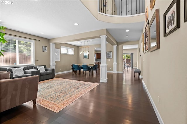 21615 SW Derby Ter, Sherwood, OR 97140 - living area with ornate columns, dark wood-type flooring, baseboards, recessed lighting, and a chandelier