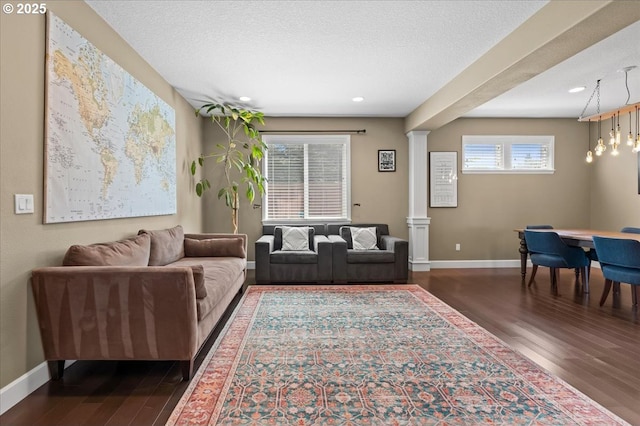 21615 SW Derby Ter, Sherwood, OR 97140 - living area with dark wood-style flooring, decorative columns, baseboards, and recessed lighting
