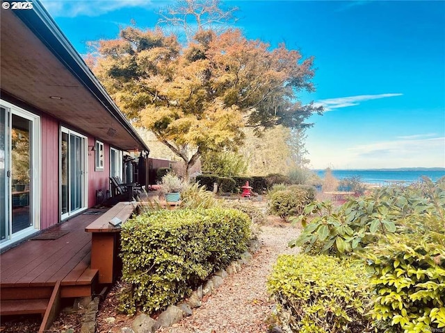 view of yard with a deck with water view