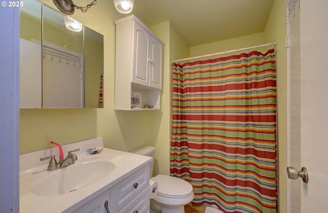 bathroom featuring vanity, curtained shower, and toilet