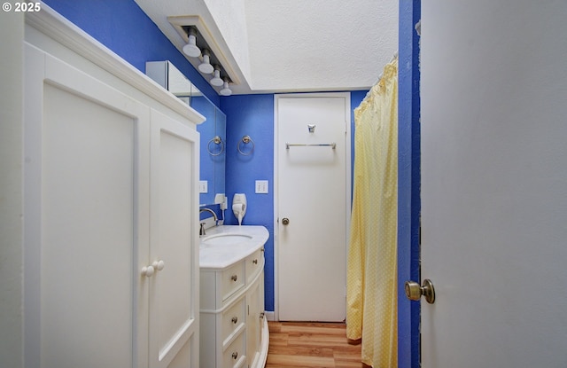 bathroom featuring a textured ceiling, wood finished floors, and vanity