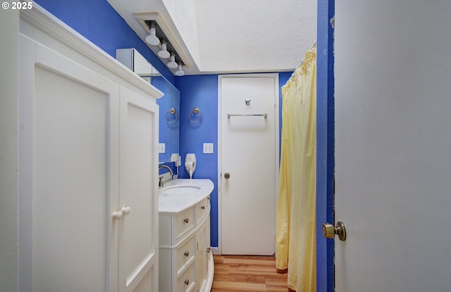 laundry area with sink, hardwood / wood-style flooring, and a textured ceiling