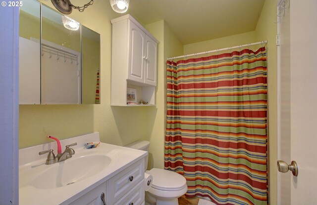 full bath with toilet, curtained shower, and vanity