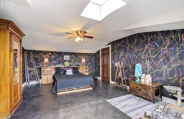 bedroom featuring wallpapered walls, vaulted ceiling with skylight, an accent wall, ceiling fan, and finished concrete floors