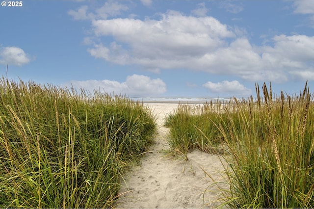 exterior space featuring a water view and a beach view