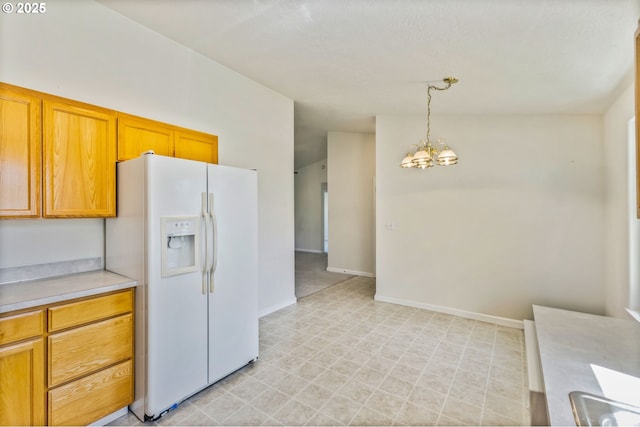 1222 Laurel Ct, Sweet Home, OR 97386 - kitchen with white refrigerator with ice dispenser, a chandelier, light countertops, light flooring, and hanging light fixtures