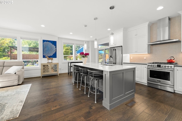 2608 N Winchell St, Portland, OR 97217 - kitchen featuring stainless steel appliances, wall chimney exhaust hood, a sink, dark wood-type flooring, and white cabinets
