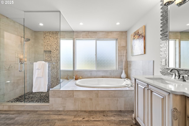 2608 N Winchell St, Portland, OR 97217 - full bathroom featuring a garden tub, wood finished floors, a shower stall, vanity, and recessed lighting