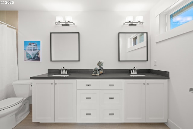 2608 N Winchell St, Portland, OR 97217 - bathroom with double vanity, toilet, and baseboards