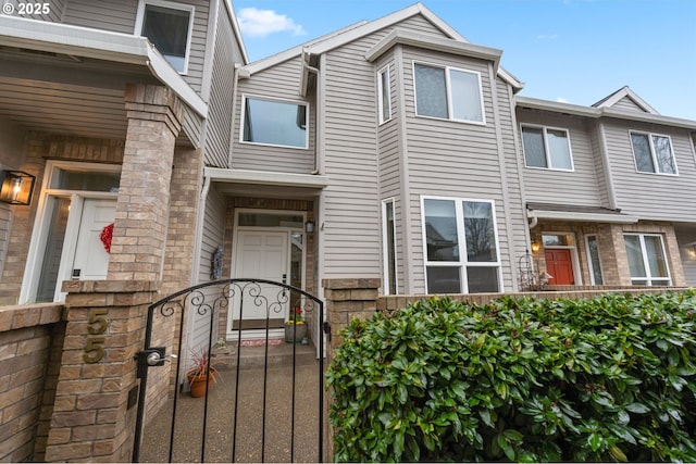 townhome / multi-family property with a fenced front yard and a gate