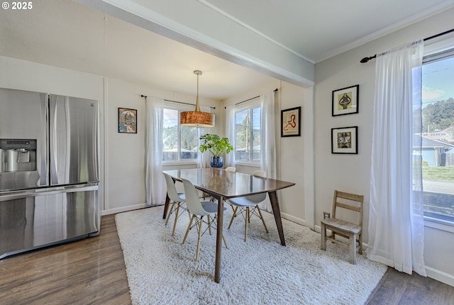 dining area featuring ornamental molding, dark wood finished floors, and baseboards