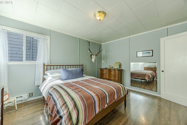 bedroom featuring ornamental molding, wood-type flooring, and baseboards