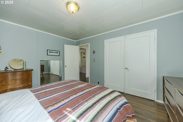 bedroom featuring dark wood-style floors, a closet, and crown molding